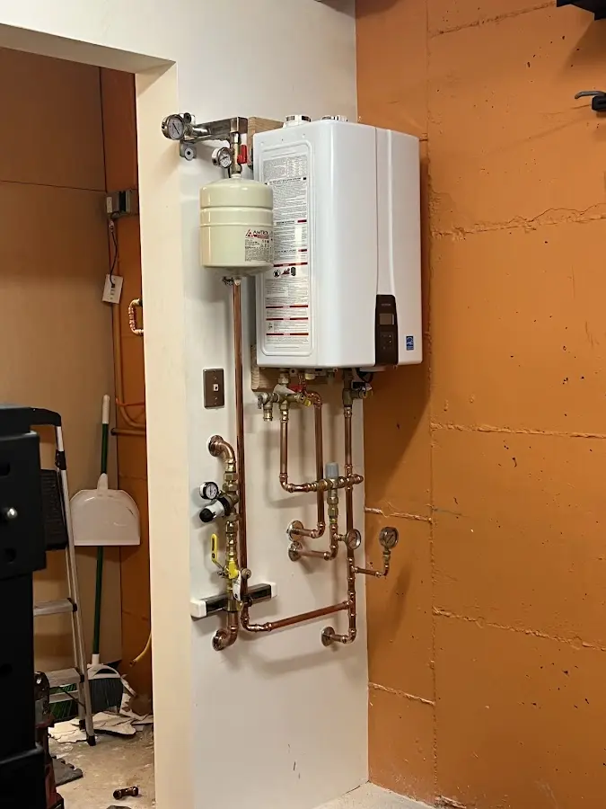 Plumbing technician inspecting water heater connections in Daleville
